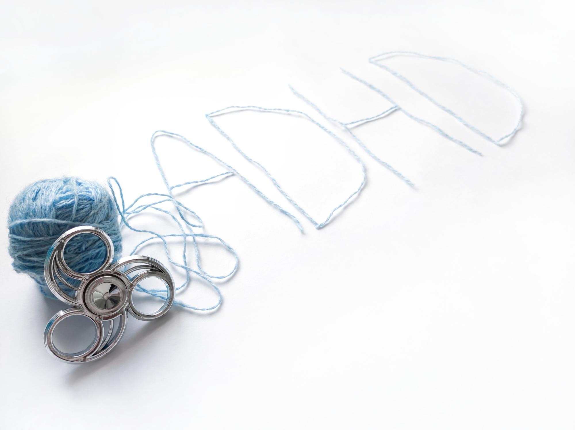 Studio table with threads, sketches and an embroidery hoop